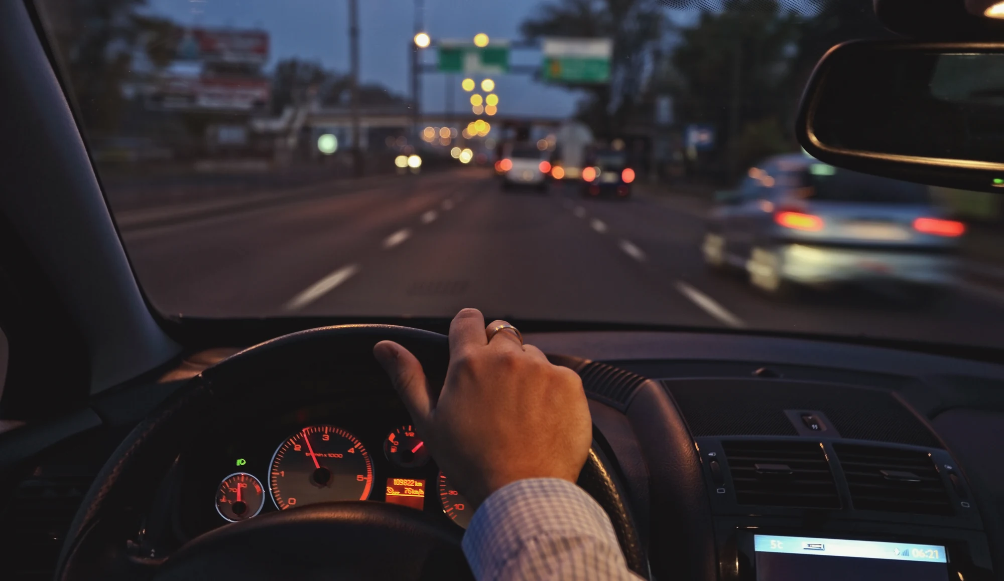 Driver traveling through city traffic in the evening